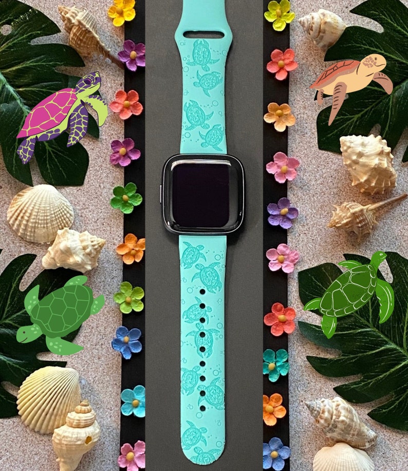 Op de afbeelding: Een lichtblauw siliconen horlogebandje met een herhalend patroon van zeeschildpadden. Het bandje is ontworpen voor een smartwatch en heeft een zwart scherm.