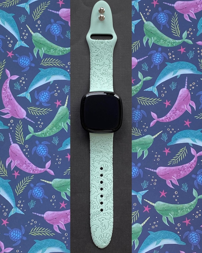 May include: A light green silicone watch band with a white narwhal and seahorse design. The band is compatible with Apple Watch.