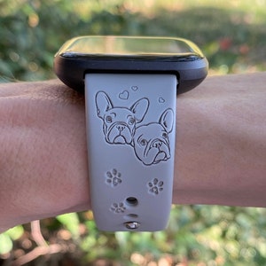 May include: A gray silicone watch band with a black watch face. The band features two French bulldog faces and paw prints.