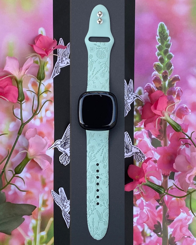 May include: A light green silicone watch strap with a floral and hummingbird design. The strap is compatible with Apple Watch Series 7.