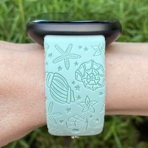May include: A light blue silicone watch band with a seashell and starfish design.