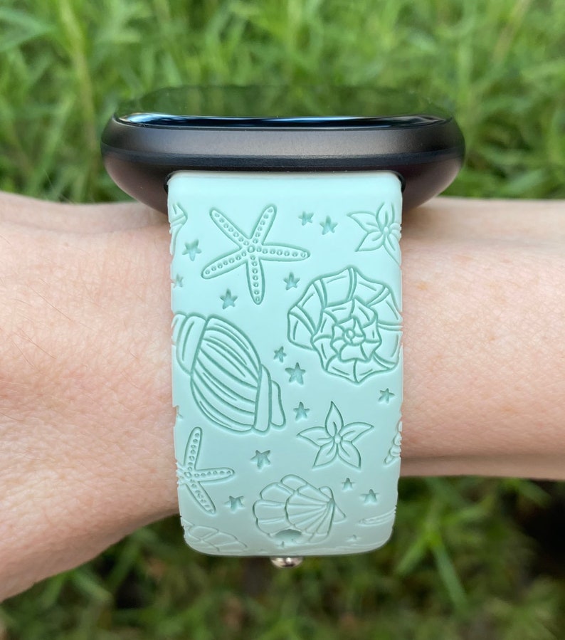 May include: A light blue silicone watch band with a seashell and starfish design.