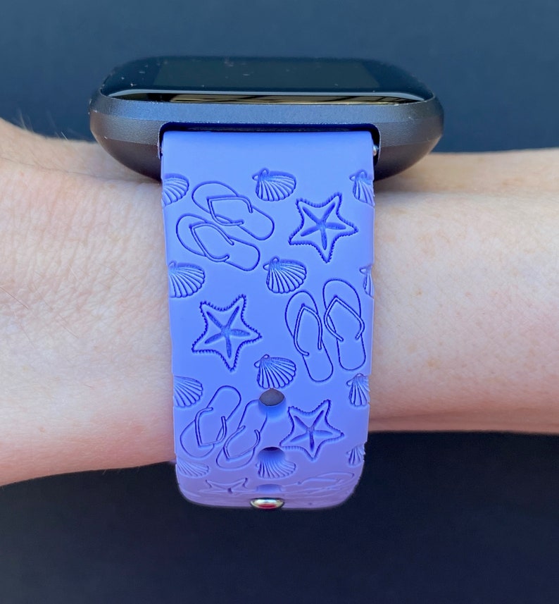 May include: A purple silicone watch band with a beach-themed design featuring flip flops, seashells, and starfish.