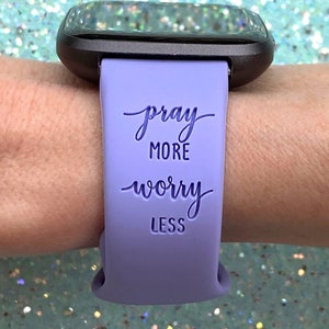 May include: A lavender silicone watch band with the text "pray more worry less" printed on it.