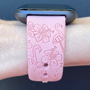 May include: A pink silicone watch band with a flamingo and hibiscus flower design.