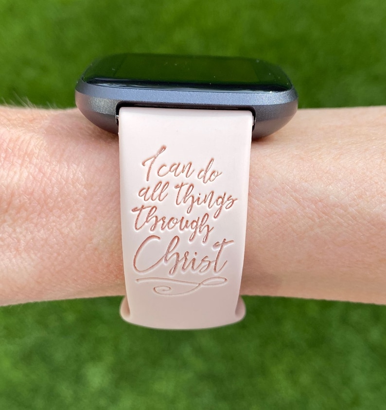 K&ouml;nnte beinhalten: Ein rosafarbenes Silikon-Armband f&uuml;r eine Uhr mit den Worten "Ich kann alles durch Christus" in Ros&eacute;gold gepr&auml;gt.