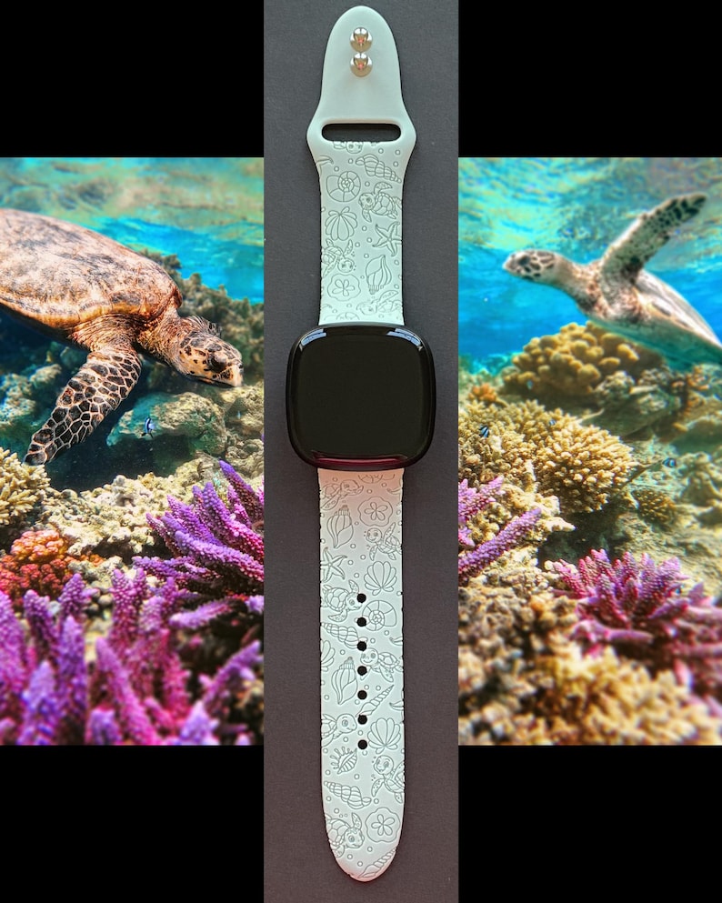 May include: A light green smartwatch band with a black screen. The band features a sea life pattern with shells, starfish, and turtles. The background shows a coral reef and sea turtles.