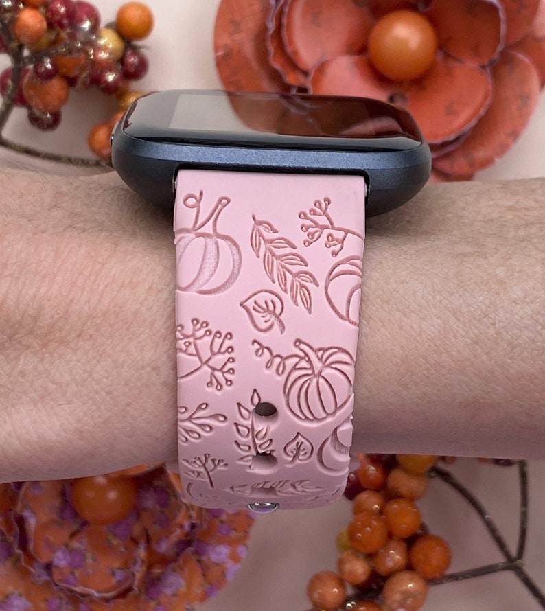 K&ouml;nnte beinhalten: Ein rosafarbenes Silikon-Armband mit einem Herbst-Design mit K&uuml;rbissen, Bl&auml;ttern und Beeren. Das Armband ist kompatibel mit Smartwatches.