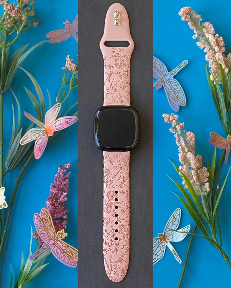 May include: A pink silicone watch band with a floral and dragonfly design. The band is compatible with smartwatches.
