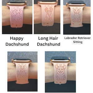 May include: A collection of rose-colored smartwatch bands, each featuring a different dog breed design. The bands display a Happy Dachshund, Long Hair Dachshund, Labrador Retriever Sitting, My Best Friend Dachshund, and Playful Corgi. Each band has a gold-colored frame.