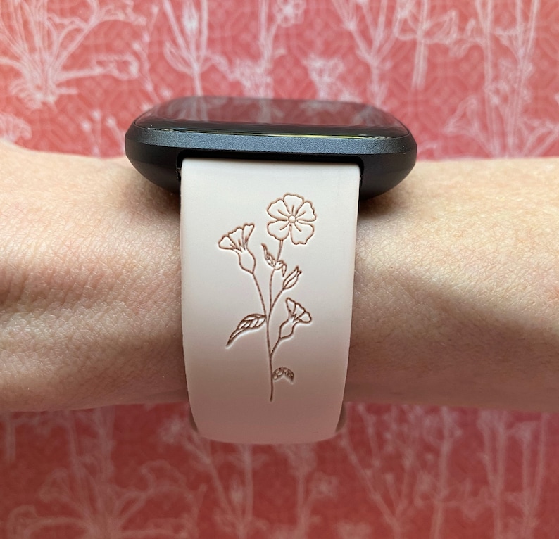 Op de afbeelding: Een wit leren horlogebandje met een bloemenpatroon. Het bandje is voor een vierkant smartwatch.