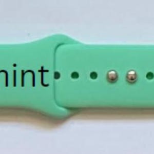 May include: A light green silicone watch band with white accents and the word "Spearmint" printed on the band.
