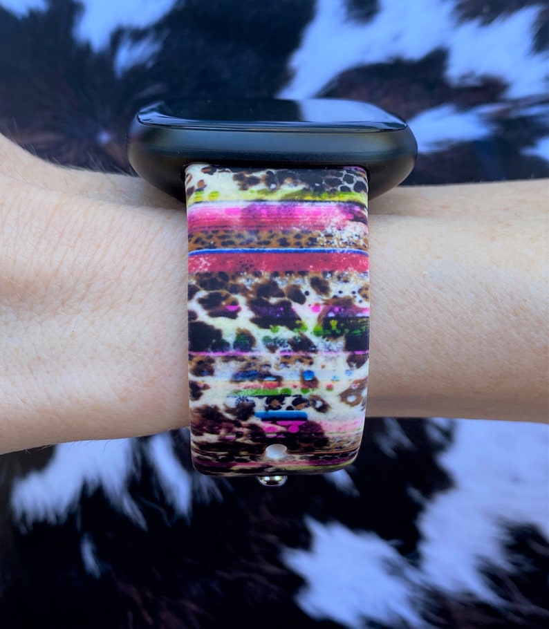 May include: A colorful watch band with a leopard print and stripes. The band is made of silicone and is compatible with Apple Watch.