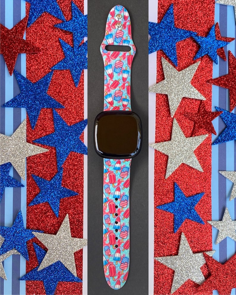 May include: A smartwatch band with a red, white, and blue popsicle print. The band is made of silicone and is compatible with most smartwatches.