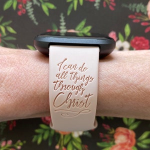 K&ouml;nnte beinhalten: Ein hellrosa Armband mit den Worten "Ich kann alles durch Christus" in kupferfarbener Schrift.