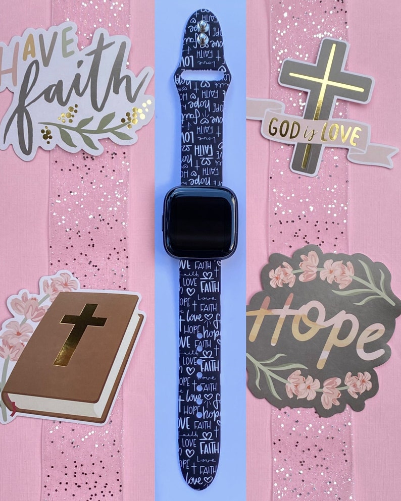 K&ouml;nnte beinhalten: Schwarz-wei&szlig;es Apple Watch Armband mit einem sich wiederholenden Muster der W&ouml;rter "Glaube", "Liebe" und "Hoffnung". Das Armband befindet sich auf einem rosa Hintergrund mit anderen religi&ouml;sen Aufklebern.