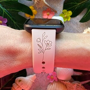 May include: A pink silicone watch band with a delicate floral design. The band is compatible with a smartwatch.