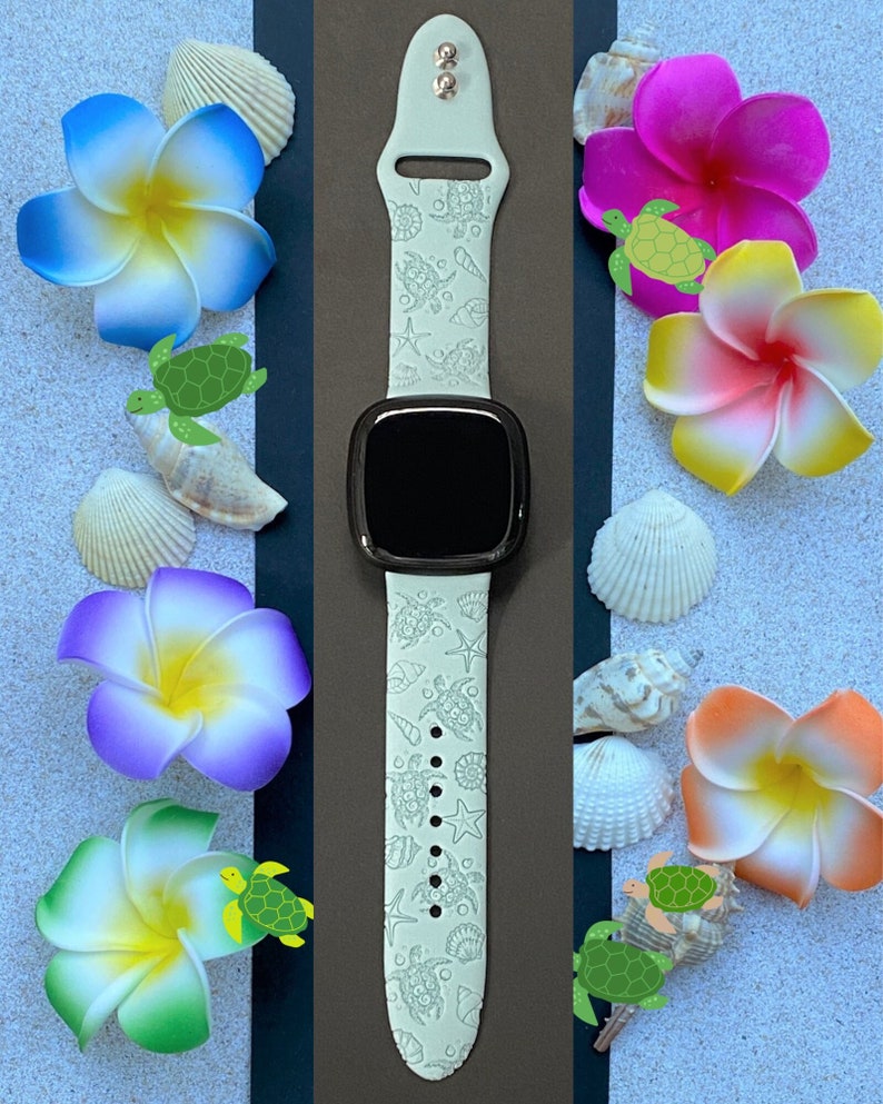 May include: A light green smartwatch band with a sea turtle pattern. The band is surrounded by colorful flowers, seashells, and small green turtle illustrations. The watch face is black.