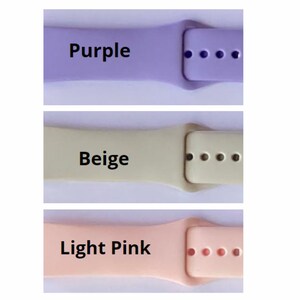 May include: Three watch bands in different colors: purple, beige, and light pink. Each band has a buckle and five holes for adjusting the fit.