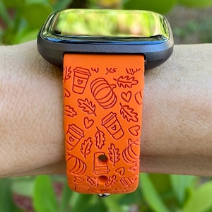 May include: Orange smartwatch band with a fall-themed design featuring coffee cups, pumpkins, leaves, and hearts.