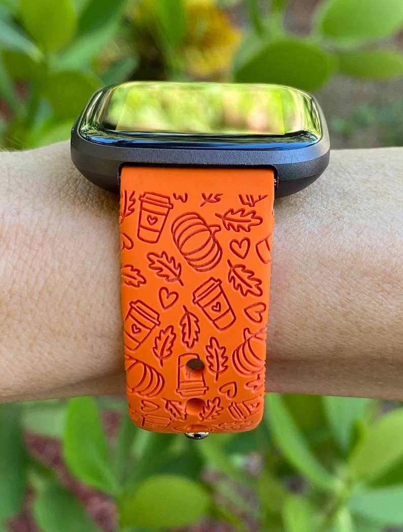 May include: Orange smartwatch band with a fall-themed design featuring coffee cups, pumpkins, leaves, and hearts.