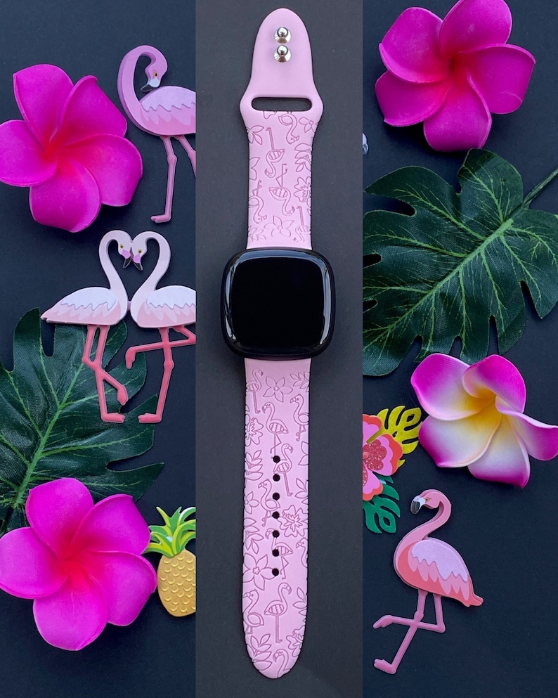 May include: Pink silicone watch band with a flamingo and floral pattern. The band is compatible with smartwatches.
