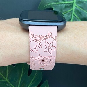 May include: A pink silicone watch band with a sloth design. The band has a white outline and is compatible with smartwatches.