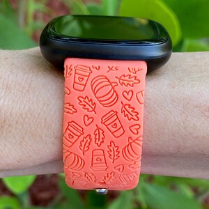 May include: Orange silicone watch band with a fall-themed design featuring coffee cups, pumpkins, and leaves.