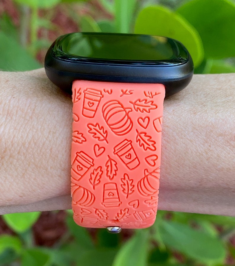 May include: Orange silicone watch band with a fall-themed design featuring coffee cups, pumpkins, and leaves.