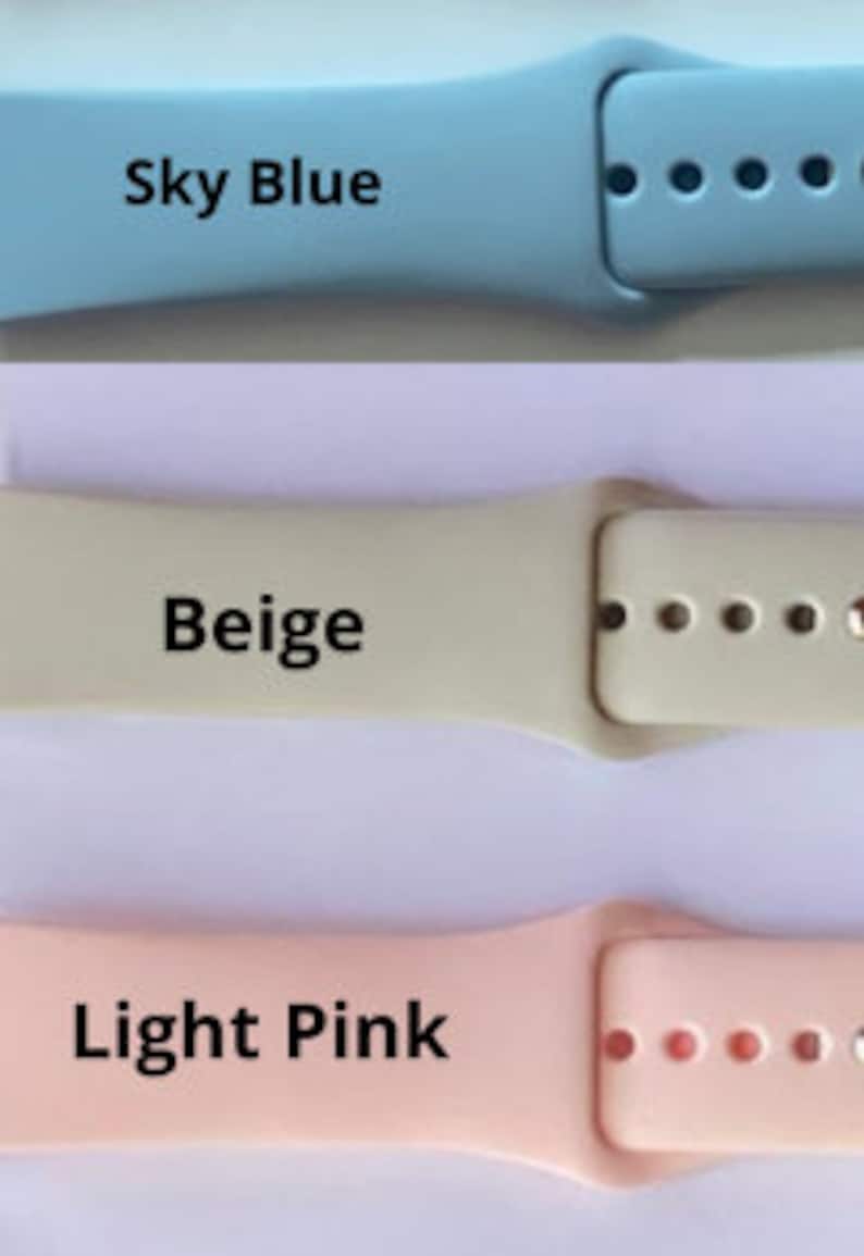 May include: Three silicone watch bands in sky blue, beige, and light pink. The bands are designed for smartwatches and have a buckle closure.