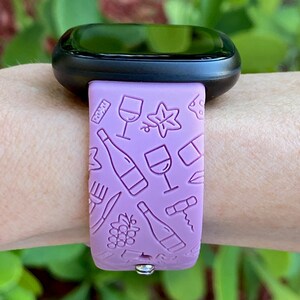 May include: A purple silicone watch band with a wine-themed design. The band features images of wine bottles, glasses, grapes, and corkscrews.