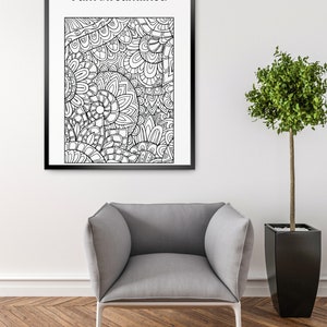 Puede incluir: Una impresión artística en blanco y negro enmarcada con el texto "I am streamlined" sobre un diseño abstracto detallado. Una butaca gris con patas blancas se encuentra debajo de la obra de arte. Un árbol en maceta está a la derecha.