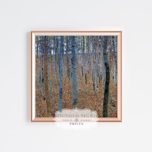 May include: A framed print of a painting depicting a forest scene with tall, slender trees in shades of blue and gray. The ground is covered in fallen leaves in shades of yellow, orange, and brown. The print is framed in a light brown frame.