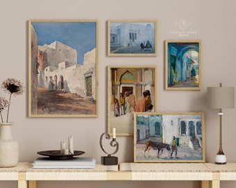 Può includere: Cinque acquerelli incorniciati che raffigurano scene di edifici e strade in una città del Medio Oriente. I dipinti sono disposti a griglia su una parete color beige chiaro sopra un tavolo di legno con un vaso di fiori secchi, candele e un supporto in metallo decorativo.