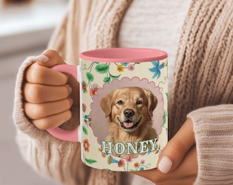 May include: A ceramic mug with a pink handle and interior. The mug features a smiling golden retriever portrait inside a scalloped frame, with the name "HONEY" below. The exterior has a floral pattern.