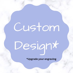 May include: A light blue circle with the text "Custom Design*" in white. The text "*Upgrade your engraving" is in black below the circle.