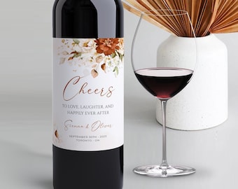 Könnte beinhalten: Eine Weinflasche mit einem weißen Etikett, das mit einem Blumendesign und dem Text "Cheers to love, laughter, and happily ever after. Jenna & Oliver September 30th, 2023 Toronto, ON" verziert ist.