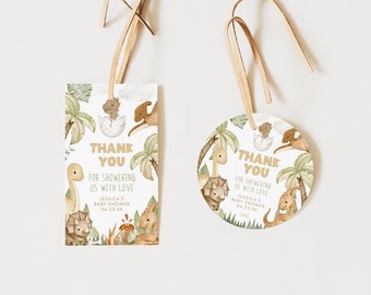 May include: Two dinosaur-themed thank you tags for a baby shower. The tags are printed with a green, brown, and white dinosaur design and the text "Thank You for showering us with love Jessica's Baby Shower 04.33.XX".