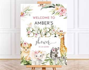May include: Welcome to Amber's Baby Shower sign with a jungle theme. The sign features a gold glitter baby word with pink flowers and green leaves. There are also illustrations of a giraffe, zebra, lion, and elephant with floral headbands.