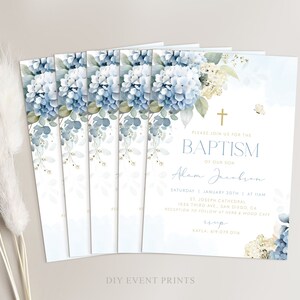 K&ouml;nnte beinhalten: Eine blaue und wei&szlig;e florale Taufeinladung mit einem goldenen Kreuz und dem Text "Bitte begleiten Sie uns zur Taufe unseres Sohnes Adam Jacabron" sowie Datum und Uhrzeit der Veranstaltung. Die Einladung enth&auml;lt auch den Ort der Zeremonie und des Empfangs.