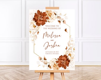 May include: A wedding welcome sign featuring a gold geometric frame and floral decorations in shades of brown and white. The text reads "Welcome to the wedding of Melissa and Joshua, September 28, 2023, Toronto, Ontario."