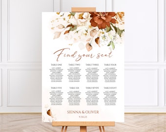 Op de afbeelding: Een zitplaatskaart voor een bruiloft met een bloemenontwerp in tinten bruin, wit en groen. De kaart vermeldt de namen van de gasten die aan elke tafel zijn toegewezen, met de namen "Sienna & Oliver" en de datum "9.30.23" onderaan.