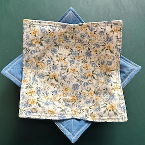 May include: A blue and white fabric bowl with a floral pattern. The bowl is folded and ready to be used.