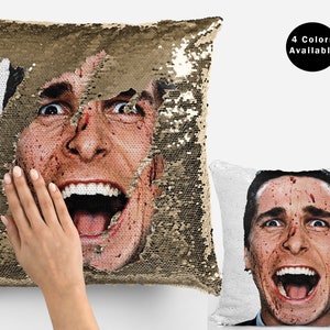 May include: A reversible sequin pillow with a gold side and a white side. The white side features a graphic of a man's face with blood splatters. The text "4 Colors Available" is visible in the upper right corner of the image.