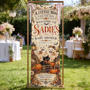 Może przedstawiać: Pionowy baner z tkaniny z napisem A LITTLE BOO IS ON THE WAY WELCOME TO SADIE'S BABY SHOWER OCTOBER 23, 2028. Wzór przedstawia dwa duszki, czarnego kota, dynie i jesienne liście na kremowym tle.