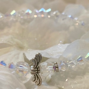 Puede incluir: Un delicado brazalete de cristal con un dije de ala de &aacute;ngel de plata. El brazalete est&aacute; hecho de cristales transparentes y es perfecto para una ocasi&oacute;n especial.