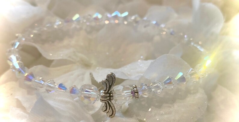Puede incluir: Un delicado brazalete de cristal con un dije de ala de &aacute;ngel de plata. El brazalete est&aacute; hecho de cristales transparentes y es perfecto para una ocasi&oacute;n especial.