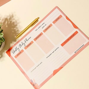 Puede incluir: Un planificador de estudios semanal rosa y blanco con secciones para cada d&iacute;a de la semana, citas motivacionales y espacio para objetivos y recordatorios. El planificador tiene el t&iacute;tulo escrito a mano "Weekly Study Planner" y el texto "This week's goal" y "It's the weekend!"