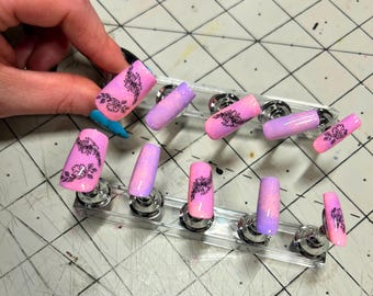 Rosa und Lila Blumenpresse auf den Nägeln