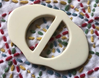 Nicely shaped white casein belt slide 1930's